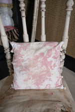 Antique pink floral cushion with pom poms