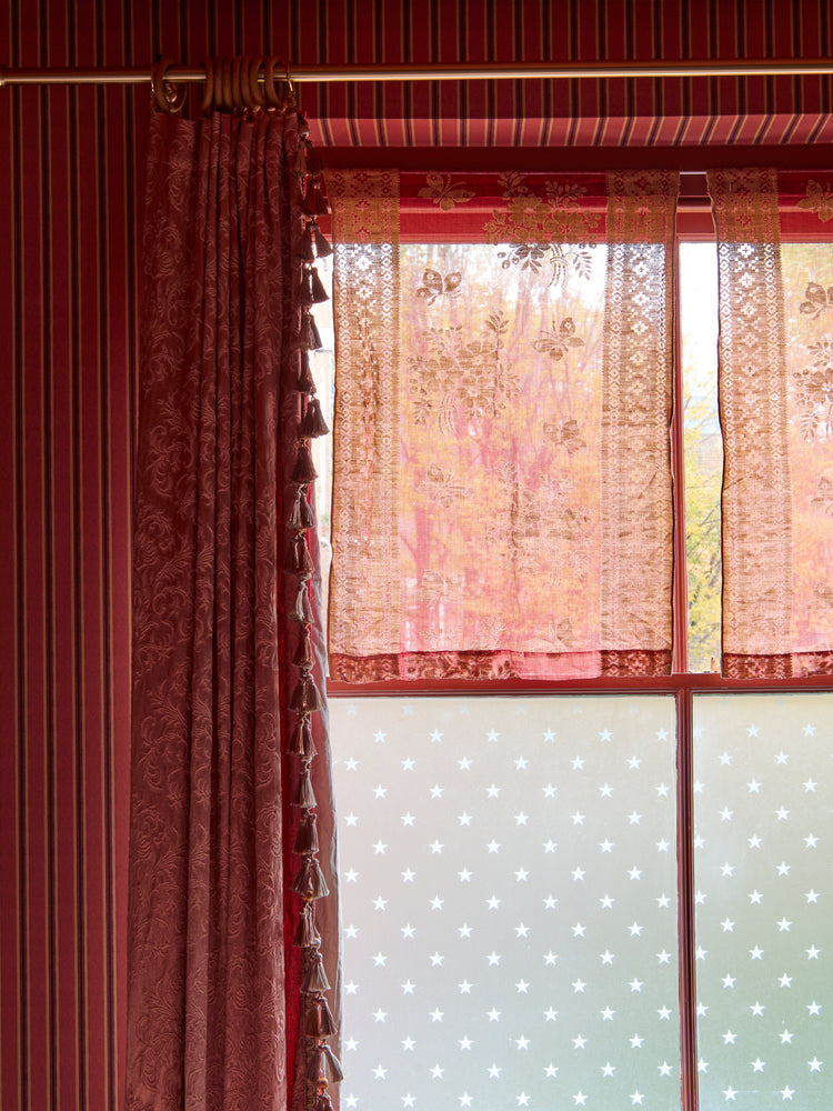 A pair of vintage red patterned voile curtains