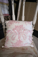Antique pink floral cushion with pom poms