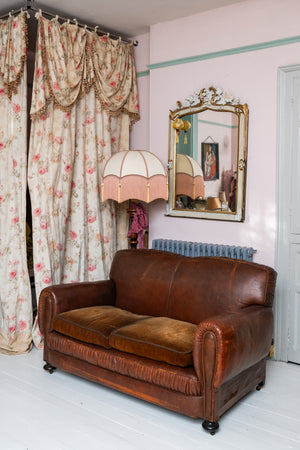 Antique leather sofa with velvet cushions