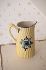 Antique yellow jug with blue flowers